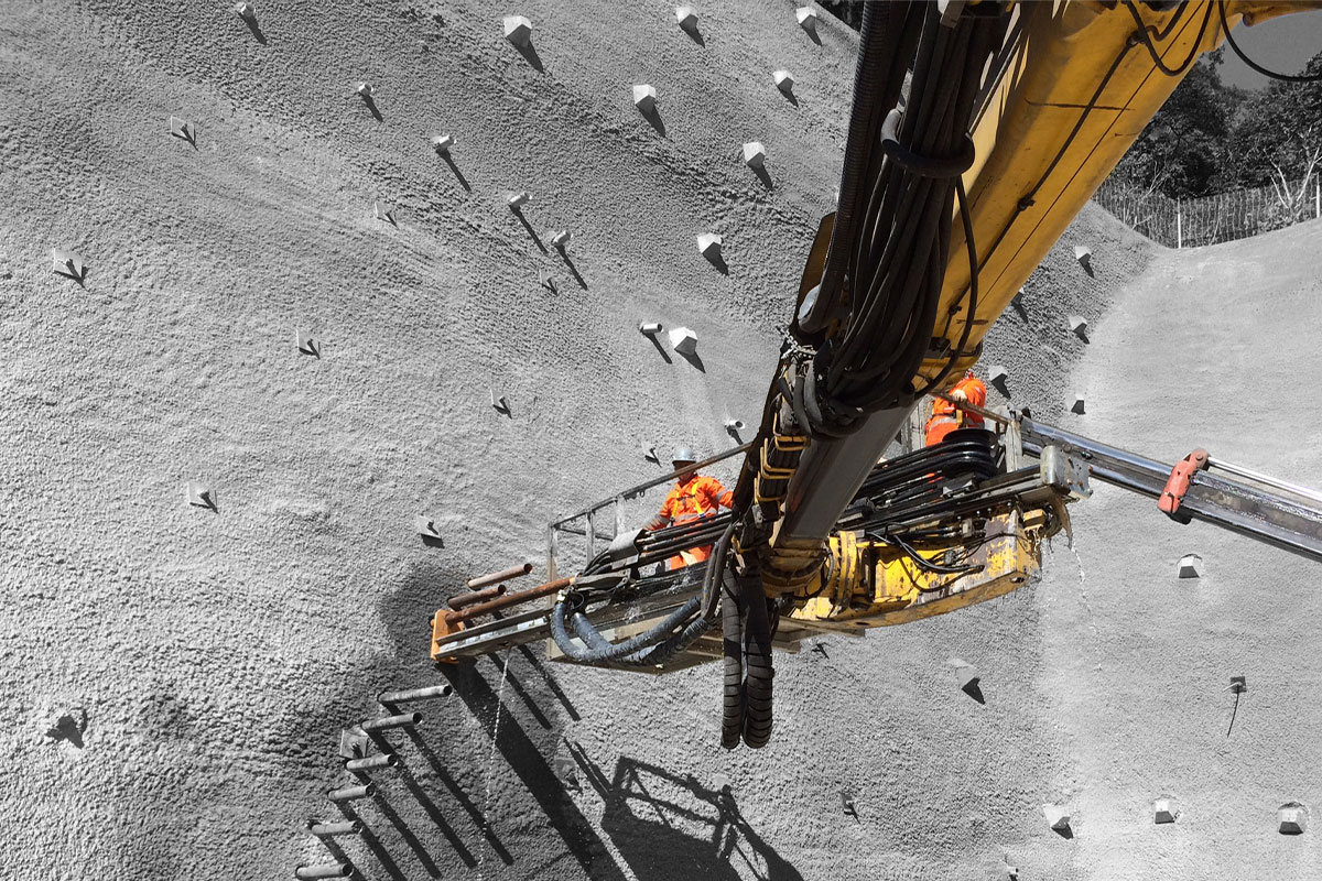 A team on a rock wall digging holes.